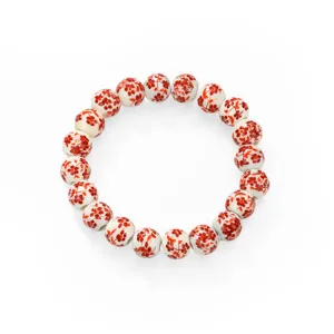Detailed view of traditional Chinese style ceramic beaded bracelet with delicate red floral pattern