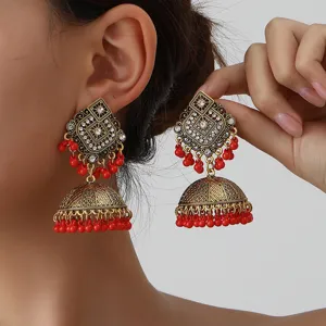Vintage chrysa kremasta skoularikia jhumka me lampera strass kai kokkina perlidia.