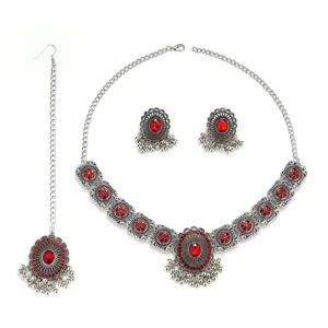 Detailed close-up view displaying intricate silver patterns and red crystal jewelry pieces.