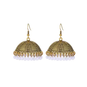 Detailed view of antique gold ethnic jhumka earrings with white beaded dangles.