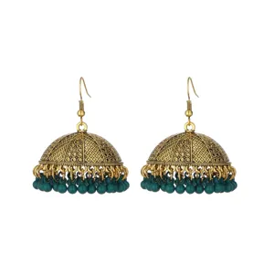 Close-up detail of vintage gold-toned ethnic Jhumka earrings with dark green bead drops.