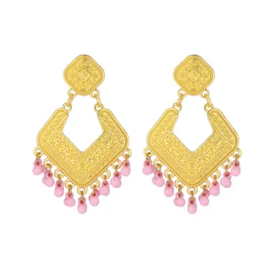 Vintage gold plated earrings with intricate engraved patterns and delicate pink beaded fringe details.