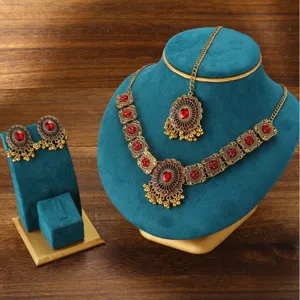 Close-up detail of retro Indian style red rhinestone choker necklace and earrings set.