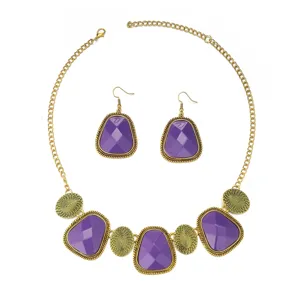 Detailed view of vintage purple stone necklace and earrings set with intricate gold metal frame.