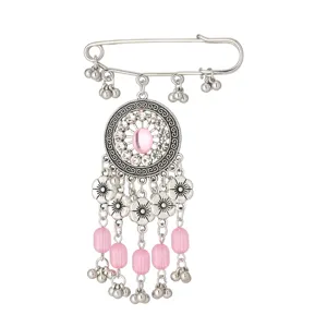 Dettaglio della spilla etnica argentata vintage con perline rosa e campanellini pendenti.