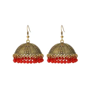 Close-up detail of vintage gold-tone ethnic Jhumka bell earrings featuring vibrant red beaded dangles.