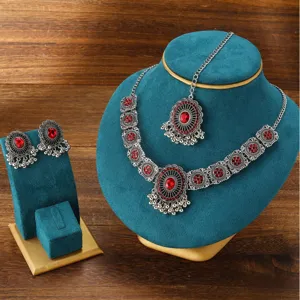 Detailed view of vintage Indian rhinestone necklace and earrings set with exquisite tassel drops.
