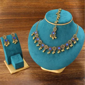 Bohemian vintage ethnic jewelry set with antique gold finish necklace, earrings, and maang tikka.