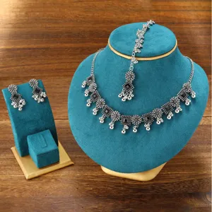 Ethnic bohemian style silver necklace earrings and maang tikka jewelry set detail display showcase.