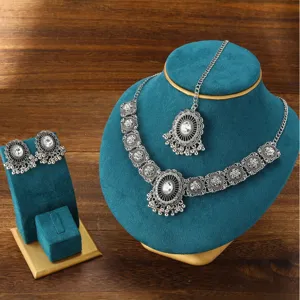 Detailed view of Indian vintage rhinestone choker necklace, earrings and maang tikka set.