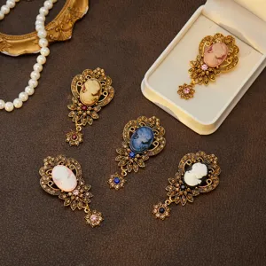 Vintage cameo brooch detail, antique gold-tone filigree crystal pin jewelry display.