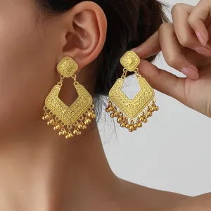 Close-up detail view of vintage gold-plated filigree diamond-shaped geometric tassel earrings.