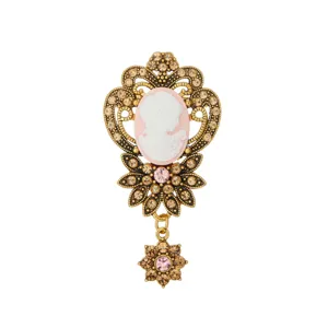 Vintage cameo brooch with antique gold filigree rhinestones and delicate dangling flower charm.