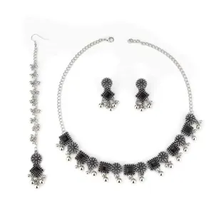 Bohemian silver jewelry set featuring a statement choker necklace, matching earrings, and maang tikka.
