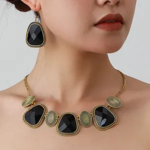 Close-up detail of vintage gold-tone ethnic choker necklace and matching geometric earrings set.