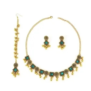 Detail view of ethnic bohemian gold necklace, earrings and maang tikka jewelry set.