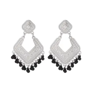 Close-up of vintage silver filigree diamond-shaped earrings with black beaded fringe details.