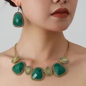 Close-up detail of the vintage green stone necklace and earring set showcasing gold texture.