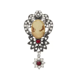 Vintage cameo brooch detailed view, antique silver tone alloy with clear rhinestones and red crystal accent.