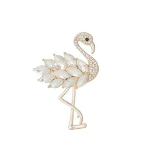 Close-up of elegant rhinestone flamingo brooch detail, sparkling crystal feathers and polished gold.