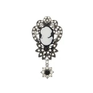 Detailed close-up of a vintage cameo brooch with sparkling rhinestones and ornate silver frame.