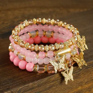 Detailed view of multi-layer pink crystal beaded bracelet set with gold butterfly charms.