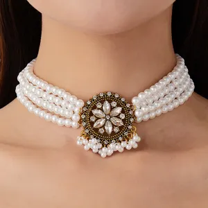 Detailaufnahme einer mehrreihigen Perlen-Choker-Halskette mit vintage Kristall-Blumenanhänger.