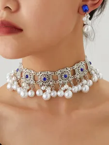 Detailed close-up of vintage silver alloy choker necklace and earrings set with pearls and blue stones