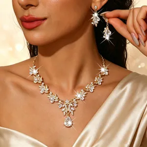 Close-up detail van luxe goudkleurige kristalen bloemen ketting en oorbellen set.
