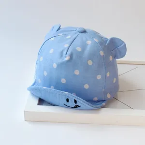 Infant polka dot baseball cap detail view, featuring cute small ears and embroidered smiley brim.