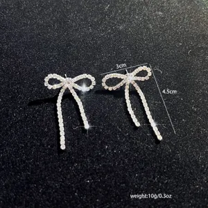 Erhöhen Sie Ihren Stil mit diesen funkelnden Strass Schleifen Quasten Ohrringen.