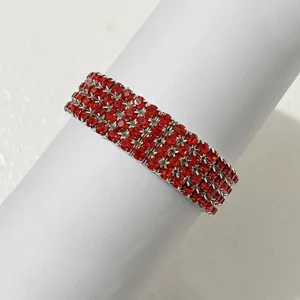 Detailaufnahme eines roten Strass-Stretcharmbands, glänzendes mehrreihiges Kristallarmband