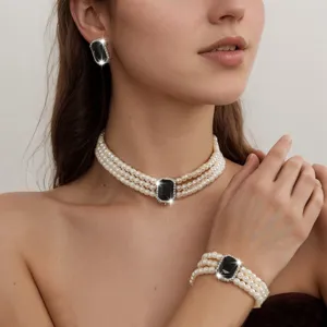 Elegant multi-layer pearl necklace bracelet and earrings set with black crystal center.