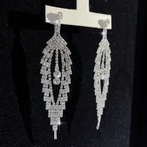 Detaillierte Nahaufnahme von langen, glitzernden Strass-Quasten-Ohrringen auf dem Ständer.