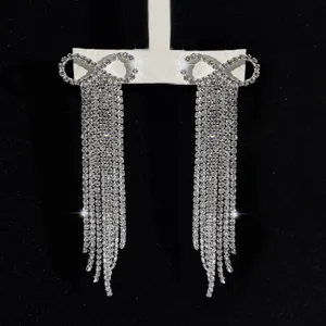Nahaufnahme der glitzernden Strass Schleife lange Quaste Ohrringe mit feinen Kristalldetails.