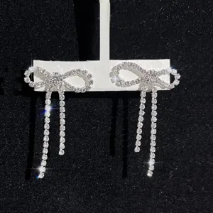 Nahaufnahme der glitzernden Strass Schleifen Quasten Ohrringe mit feinen Kristalldetails.