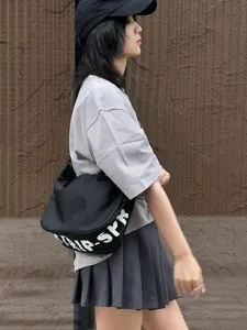 Detailed showcase of black crescent nylon cross-body shoulder bag featuring stylish white text.