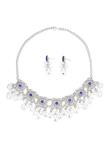 Close-up detail of vintage bohemian silver pearl necklace and crystal earrings jewelry set.