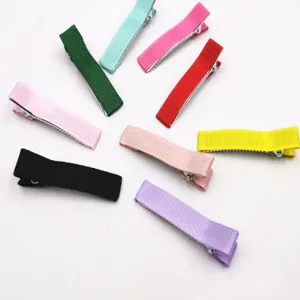 Close-up view of colorful grosgrain ribbon wrapped hair clips, fine fabric texture details.