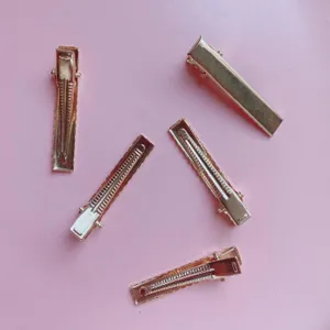 Detailed view of golden metal square hair clips with spring design, perfect for stylish daily hairstyles.