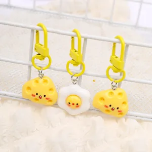 Close-up detail showing cute cheese and fried egg keychains hanging neatly on grid.