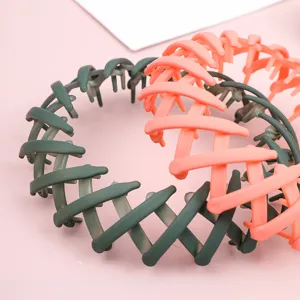 Detail view of expandable bird's nest hair clip bun maker in pink and green colors.