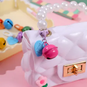 Cute pink quilted mini handbag pendant with pearl handle and bell charm for cute accessories.