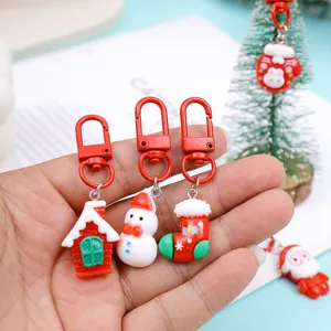 Close-up detail shot of cute resin Christmas tree snowman house keychains and hanging pendants.