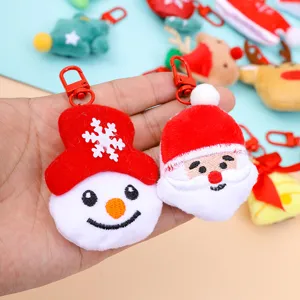 Cute Christmas plush keychain detail showing soft Santa and snowman cartoon holiday gift pendant.