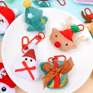 Christmas plush keychain detailed view showing cute Santa, reindeer, snowman and tree pins.