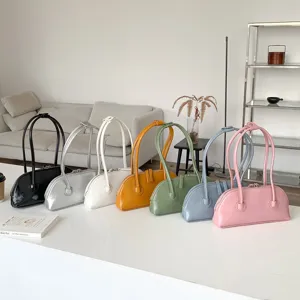 Detailed view of colorful underarm shoulder bags neatly displayed on white table surface.
