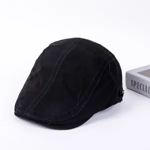 Primer plano detallado de la gorra plana clásica de algodón negro con costuras finas.
