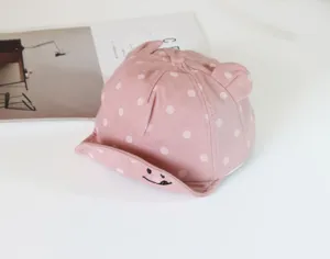 Cute pink baby baseball cap detail, soft brim with embroidered smiley and adorable animal ears.