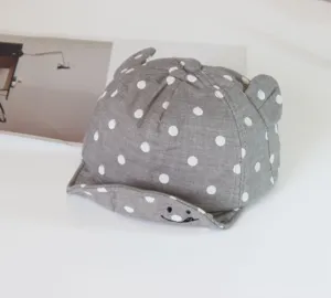 Detailed view of grey polka dot baby baseball cap with cute bear ears and smile design.